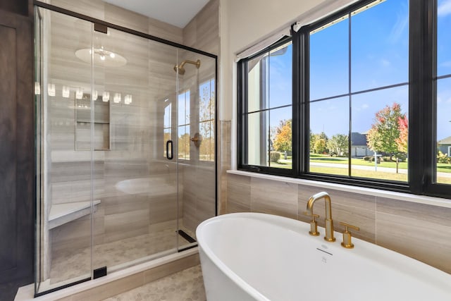 bathroom featuring plenty of natural light, tile walls, separate shower and tub, and tile patterned flooring