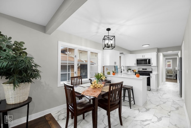 dining space with sink, a notable chandelier, and beamed ceiling