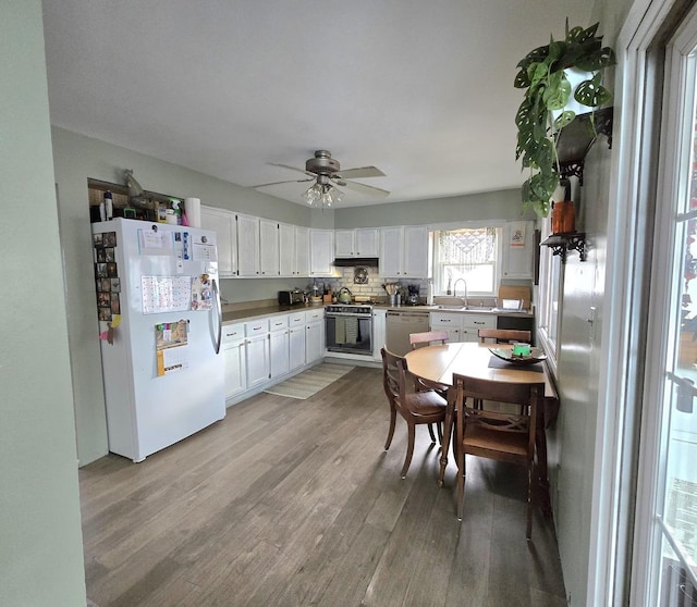 kitchen featuring wall oven, white cabinets, white fridge, and light wood-type flooring