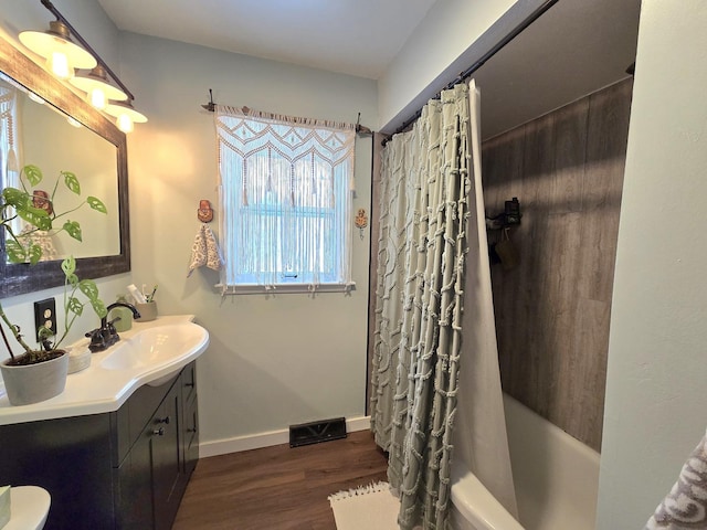 bathroom featuring hardwood / wood-style floors, vanity, and shower / tub combo