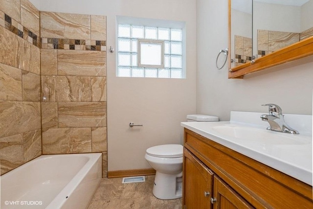 full bathroom featuring toilet, tiled shower / bath, and vanity