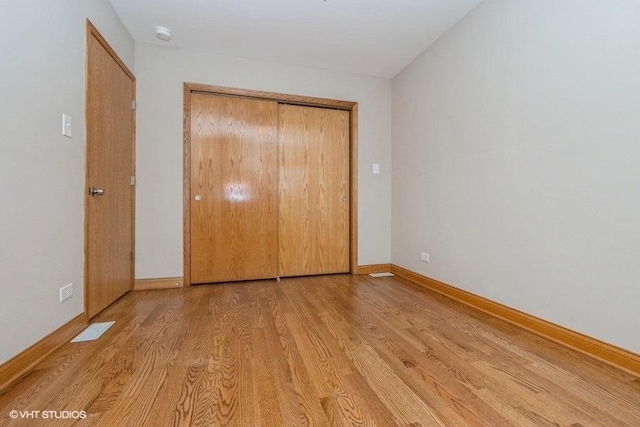 unfurnished bedroom featuring light wood-type flooring and a closet