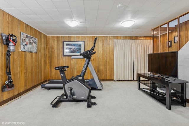 workout room with light carpet and wooden walls