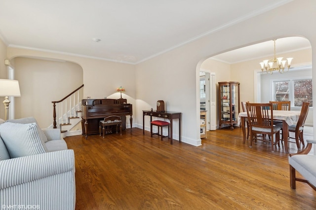 living room with wood-type flooring, a notable chandelier, and crown molding