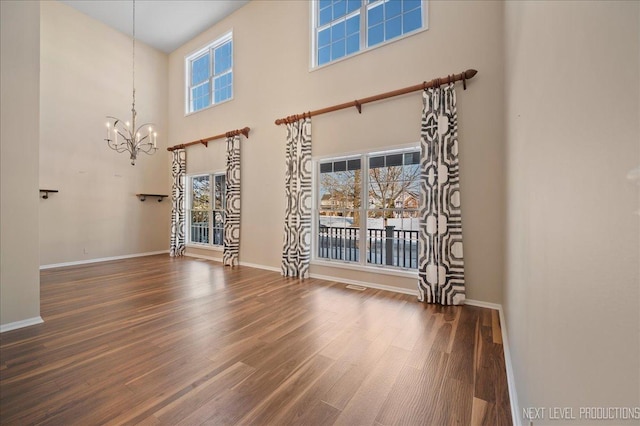 interior space featuring a high ceiling, dark hardwood / wood-style floors, and a chandelier