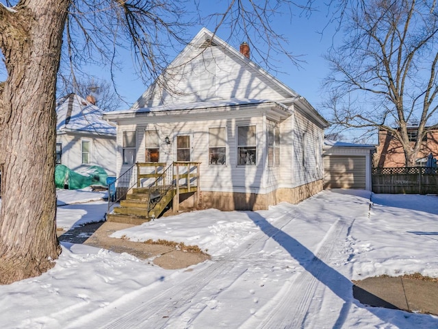 view of front of house featuring a garage and an outbuilding