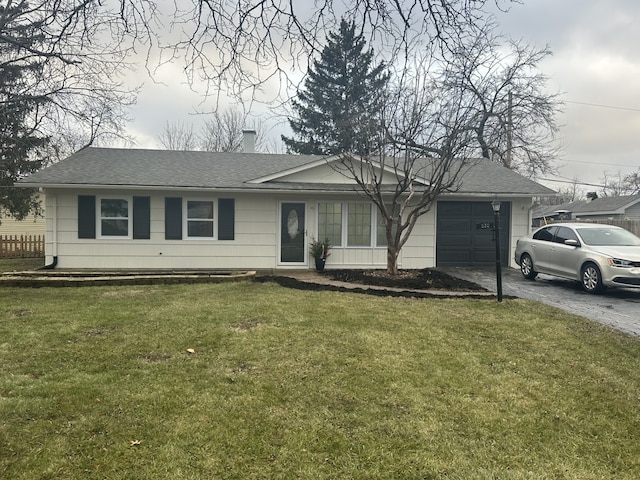 ranch-style house featuring a front lawn and a garage