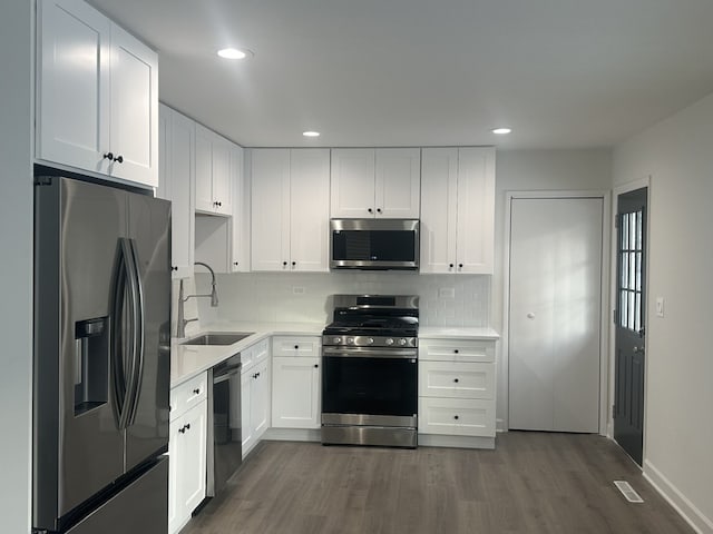 kitchen featuring dark hardwood / wood-style floors, stainless steel appliances, white cabinetry, and sink