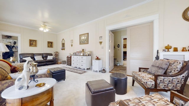 carpeted living room with crown molding and ceiling fan