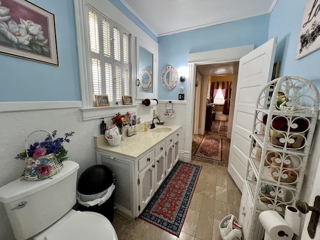 bathroom with vanity, toilet, and crown molding