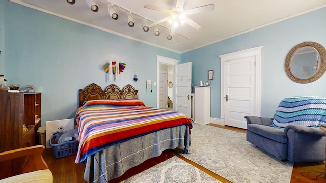 bedroom featuring ceiling fan, hardwood / wood-style floors, ornamental molding, and track lighting