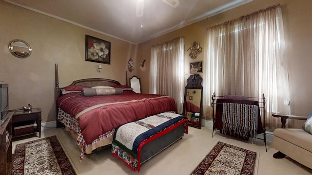 carpeted bedroom with ceiling fan, a baseboard radiator, and crown molding