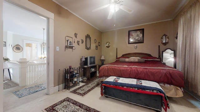 carpeted bedroom with ceiling fan and ornamental molding