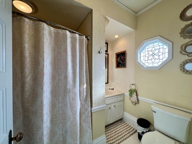 bathroom with vanity, toilet, and crown molding