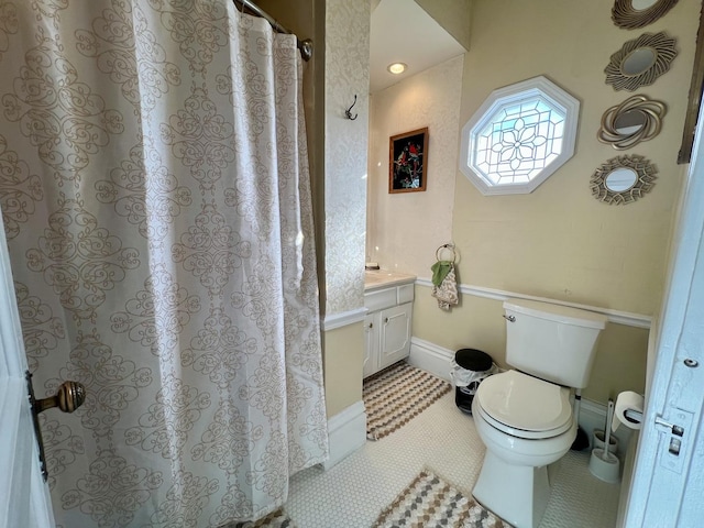 bathroom with toilet, tile patterned floors, and vanity