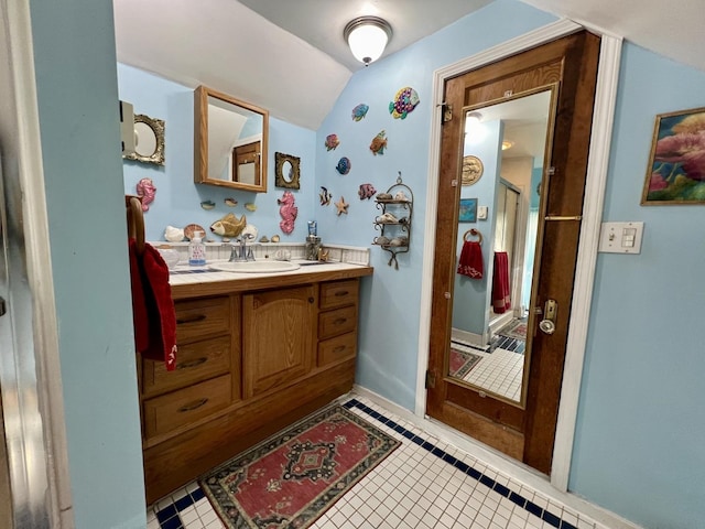 bathroom with tile patterned flooring, walk in shower, lofted ceiling, and vanity