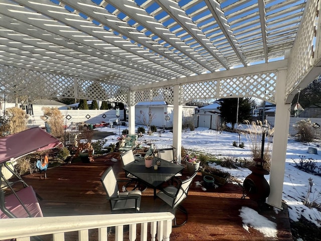 snow covered deck with a storage unit and a pergola