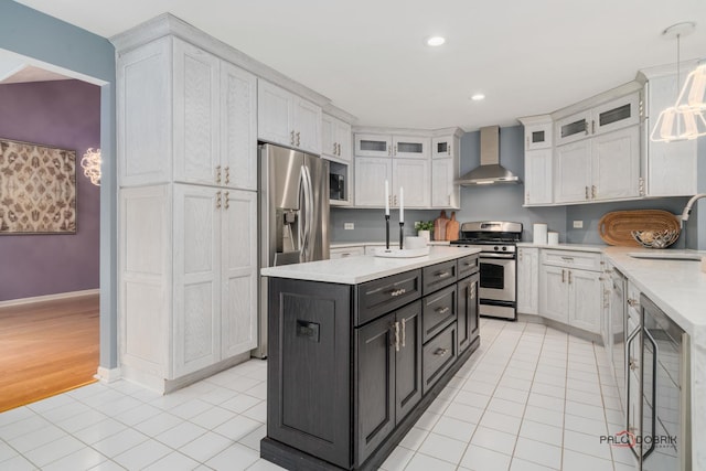 kitchen with pendant lighting, white cabinets, wall chimney range hood, stainless steel appliances, and sink