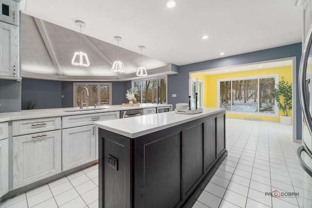 kitchen with decorative light fixtures, a center island, light tile patterned flooring, sink, and white cabinets