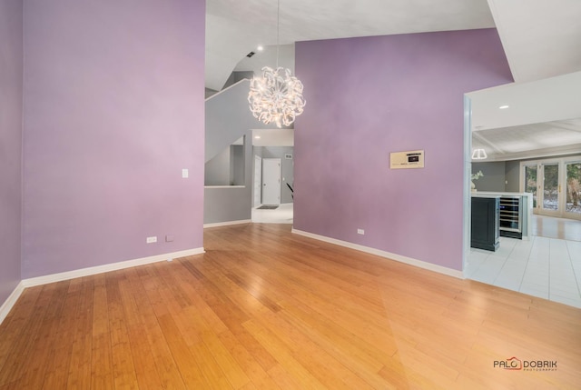 unfurnished living room with a chandelier and light hardwood / wood-style flooring