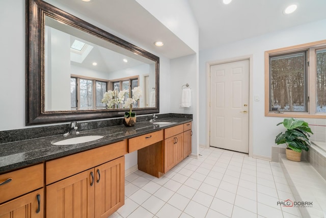 bathroom featuring tile patterned floors, vanity, and a skylight