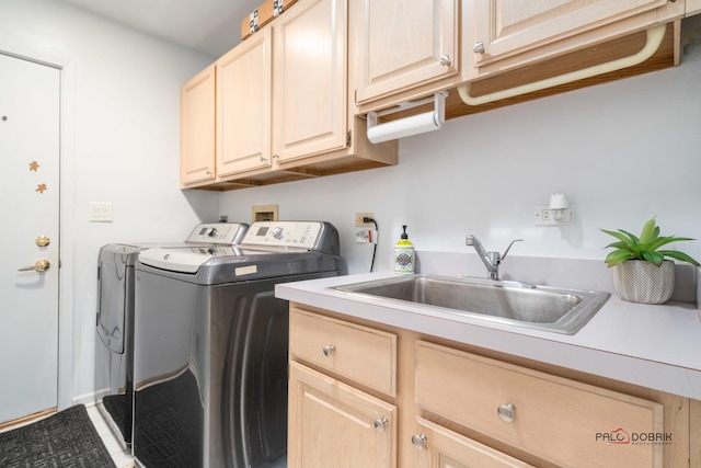 washroom featuring cabinets, sink, and washing machine and clothes dryer