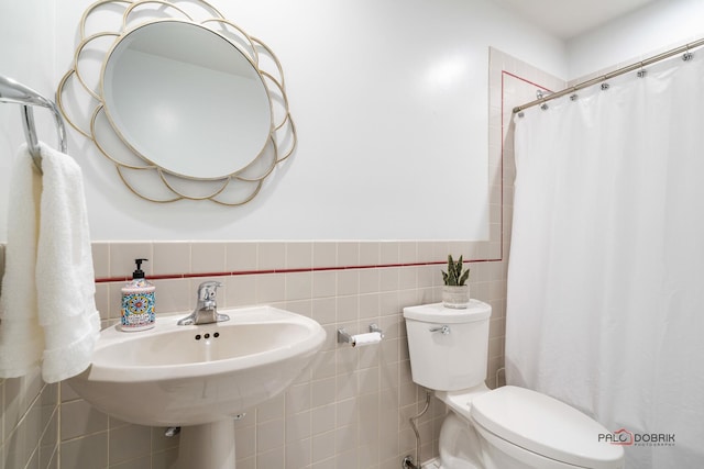 bathroom featuring toilet, tile walls, and walk in shower