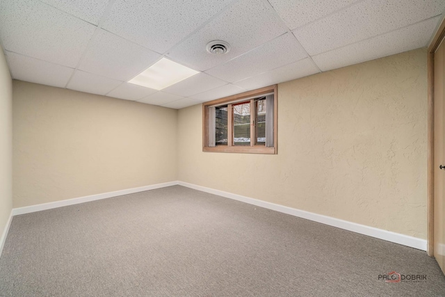 carpeted spare room with a drop ceiling