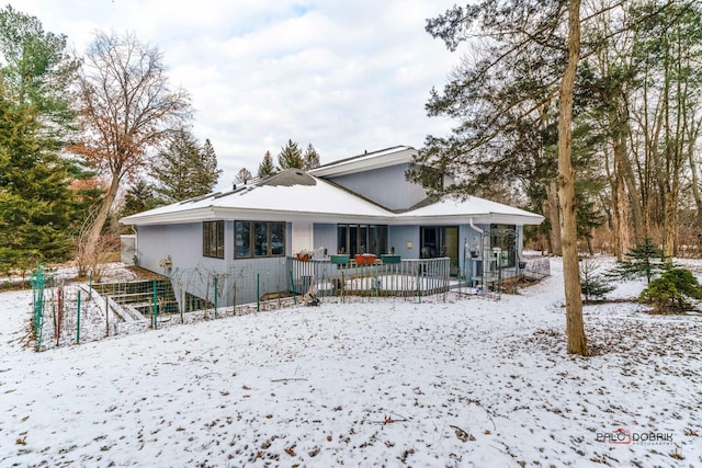 snow covered back of property with covered porch