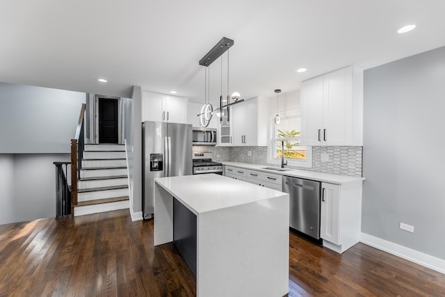 kitchen with white cabinets, pendant lighting, a center island, and stainless steel appliances