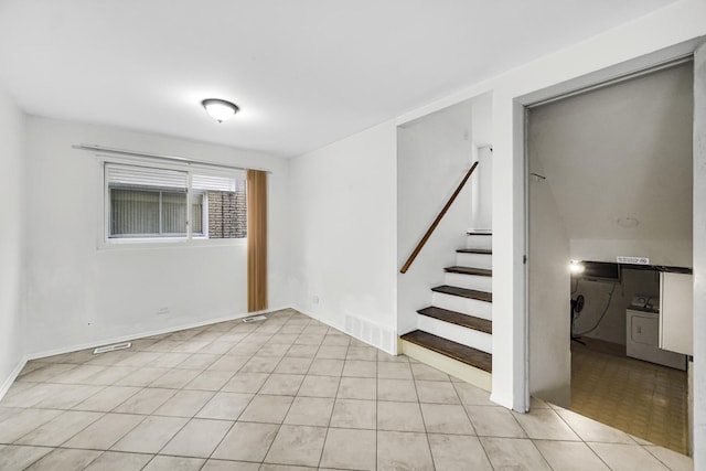 interior space with light tile patterned floors and washing machine and clothes dryer