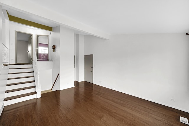 unfurnished room featuring dark hardwood / wood-style floors and lofted ceiling with beams