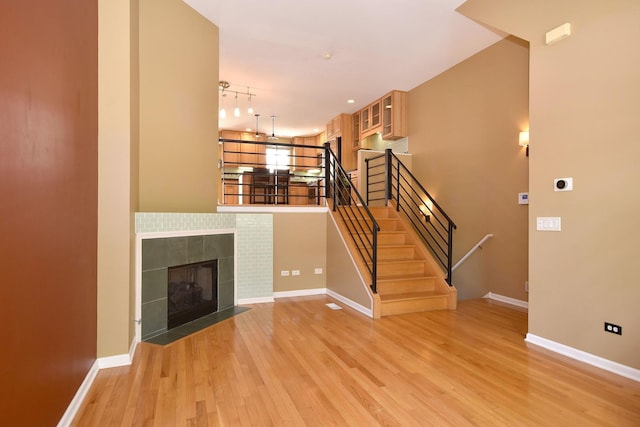 unfurnished living room with a fireplace, light hardwood / wood-style floors, and track lighting