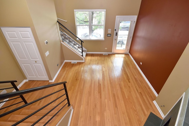 entrance foyer with wood-type flooring and a towering ceiling