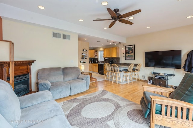 living room featuring ceiling fan and light hardwood / wood-style floors