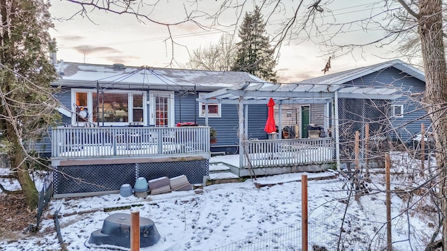 snow covered rear of property featuring a wooden deck