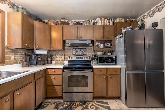 kitchen featuring decorative backsplash, appliances with stainless steel finishes, exhaust hood, and light countertops