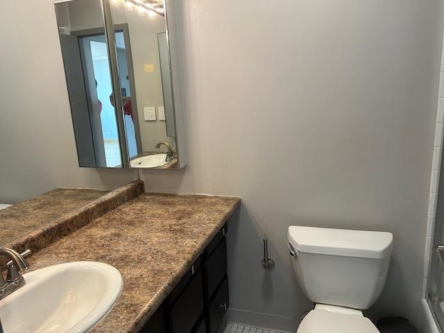 bathroom featuring vanity, a shower with shower door, and toilet