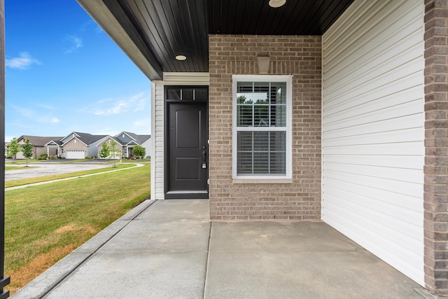 view of exterior entry with a lawn