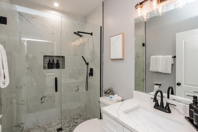 bathroom with a shower with door, vanity, and toilet