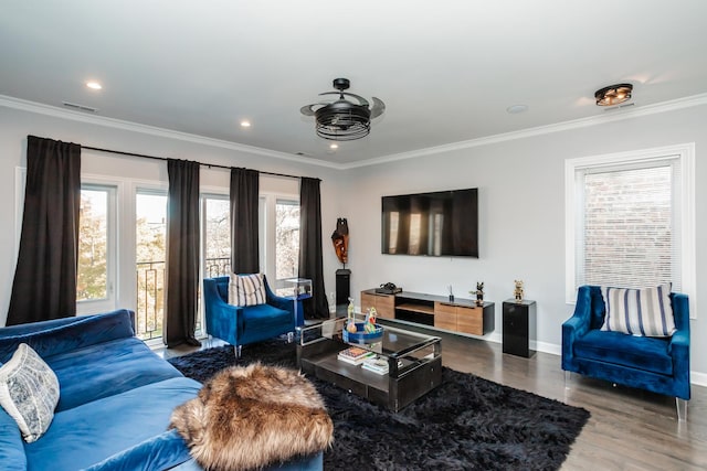 living room featuring hardwood / wood-style floors, ceiling fan, a healthy amount of sunlight, and ornamental molding