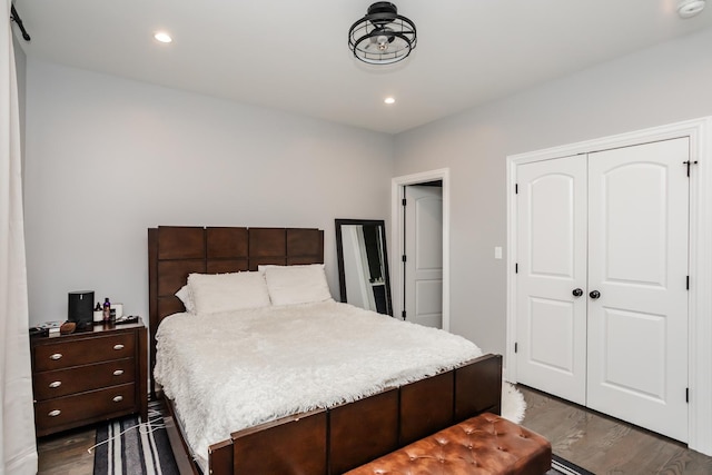 bedroom with dark hardwood / wood-style flooring and a closet