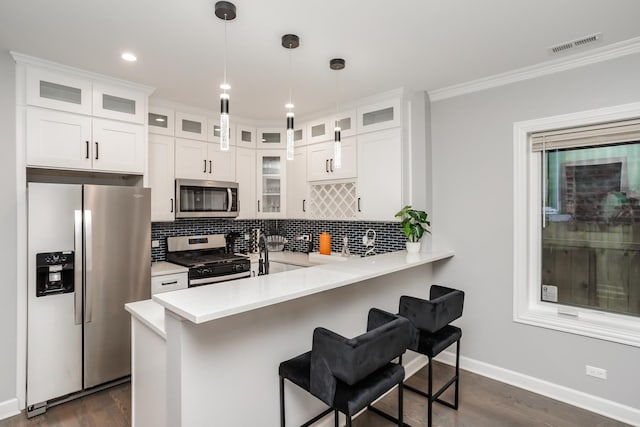 kitchen with pendant lighting, a breakfast bar, white cabinetry, kitchen peninsula, and stainless steel appliances