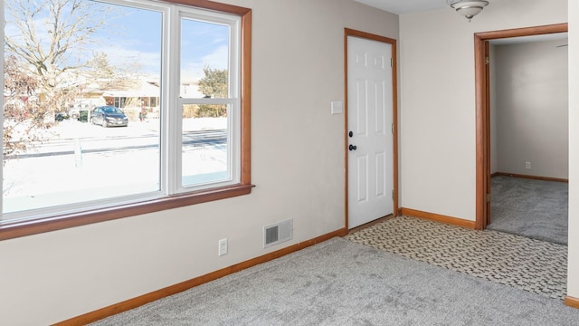 foyer entrance featuring plenty of natural light and light carpet