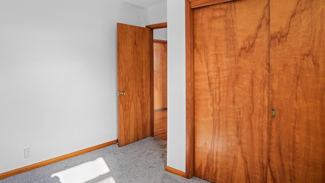 unfurnished bedroom with light carpet and a closet