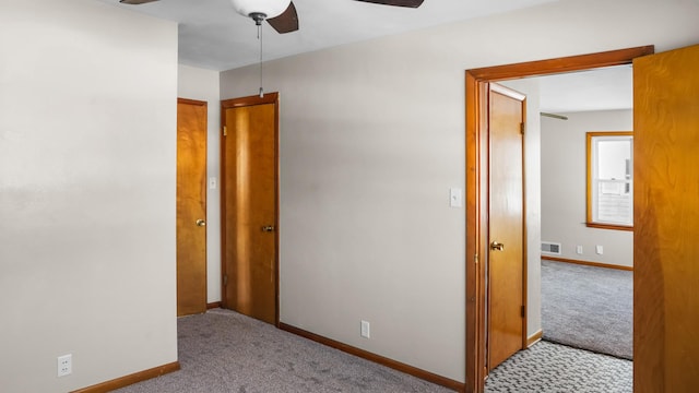 unfurnished bedroom with light colored carpet and ceiling fan