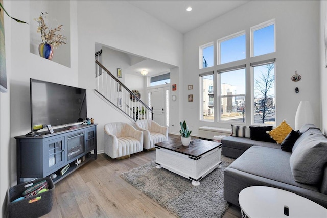 living room with a high ceiling and light hardwood / wood-style flooring