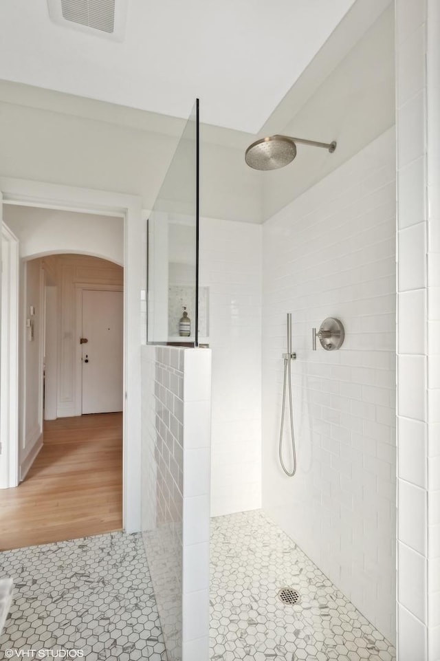 bathroom featuring a tile shower and tile patterned flooring