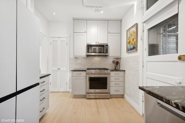 kitchen featuring tasteful backsplash, white cabinetry, light hardwood / wood-style flooring, and stainless steel appliances