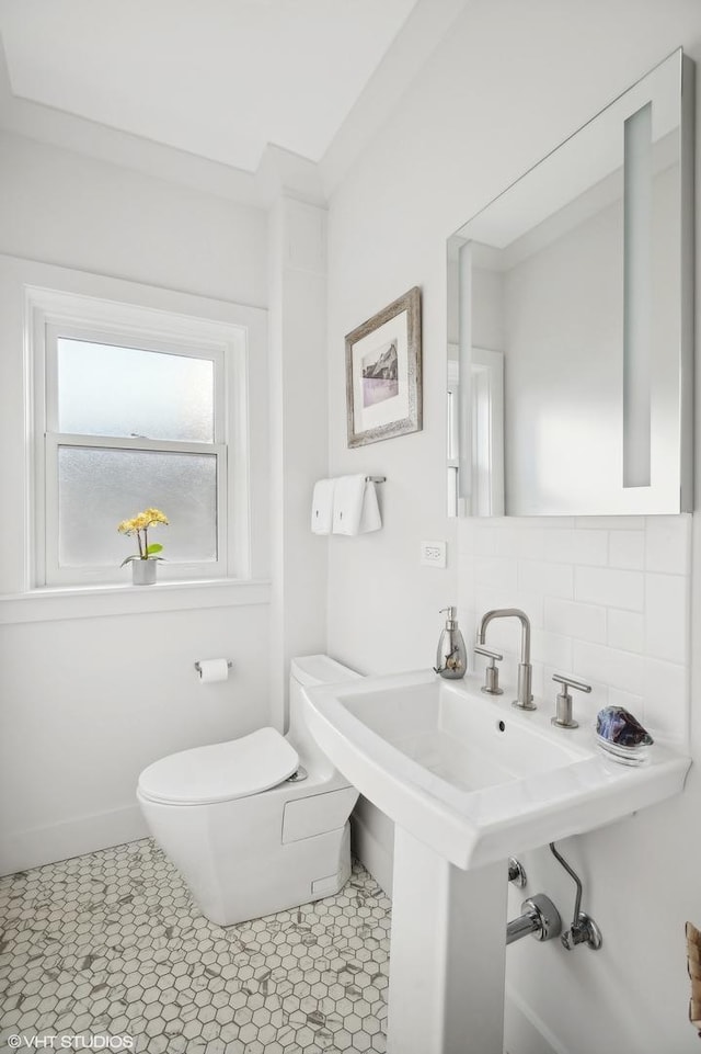 bathroom with tile patterned flooring, decorative backsplash, and toilet